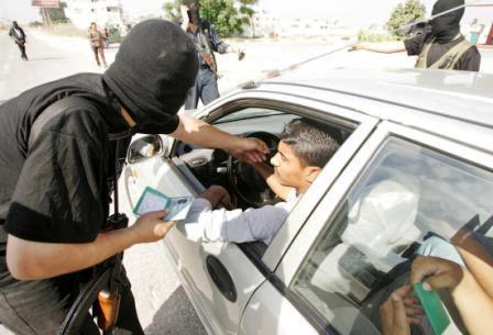 رجل من مليشيات حماس يفتش سيارة احد المواطنين