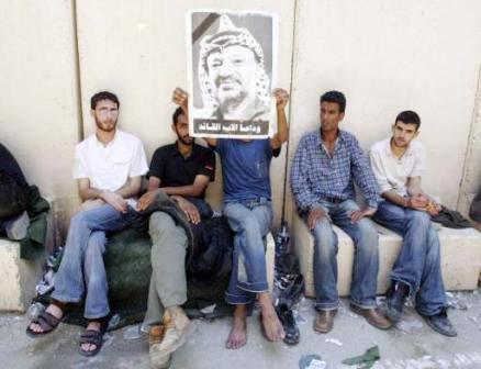 فلسطينيون يرفعون صورة الزعيم عرفات في معبر ارينز مغادرين غزة