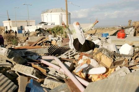 امرأة فلسطينية تقف فوق اطلال منزلها المهدم بصواريخ إسرائيلية