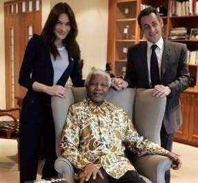 الرئيس الفرنسي نيكولا ساركوزي وزوجته كارلا بروني يقفان خلف الزعيم الجنوب افريقي نلسون مانديلا