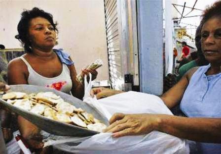 إمرأة في كوبا تتلقى حصه من الطعام