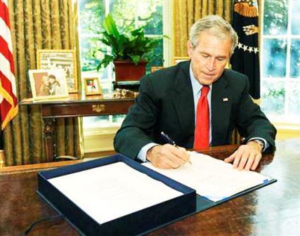 الرئيس الأمريكي جورج بوش يوقع خطة الإنقاذ المالي في المكتب البيضاوي بعد موافقة مجلس النواب عليها أمس الجمعة