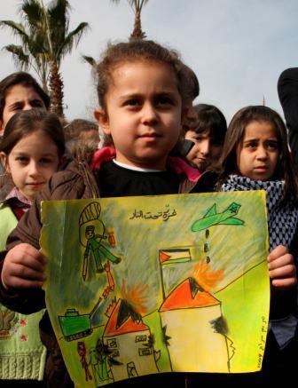 طفلة ترفع لوحة رسمتها تدين العدوان الإسرائيلي على غزه في أثناء مظاهرة ضد إسرائيل في دمشق بسوريا يوم أمس.