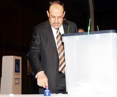 المالكي يغمس إصبعه في الحبر البنفسجي أثناء تصويته في الانتخابات العراقية بمركز اقتراع في بغداد امس