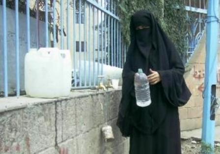 إمرأة تتسول الماء من إحدى الوزرارت في صنعاء