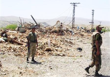 جنديان باكستانيان أمام متاجر سويت بالأرض أثناء عملية عسكرية في قرية جنوب وزيرستان يوم 18 مايو