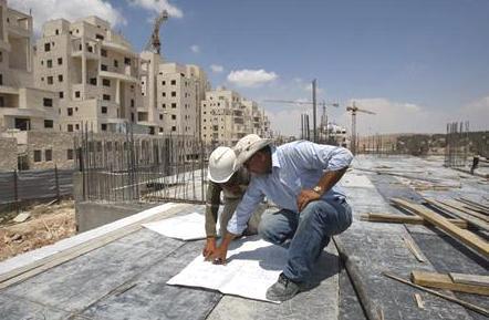 عاملان في موقع بناء بمستوطنة بالقرب من القدس المحتلة