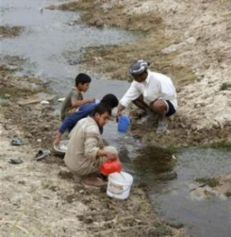 عراقيون يحصلون على المياه من نهير في بلدة بمحافظة الديوانية