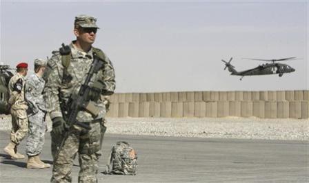 مجند أمريكي يقف للحراسة بينما تحلق طائرة هليكوبتر أمريكية فوق قاعدة عسكرية في إقليم غازني