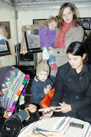 امرأة يمنية تنقش على كف فتاة أوروبية نقشة الحناء