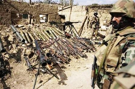 جنديان باكستانيان يقفان بجوار أسلحة وذخيرة صودرت خلال عمليات عسكرية ضد طالبان في وزيرستان الجنوبية.