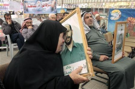 عجوز فلسطينية تبكي وهي تحتضن صورة ابنها الأسير لدى اسرائيل وذلك أثناء احتجاج في مدينة غزة للمطالبة بالافراج عن الأسرى