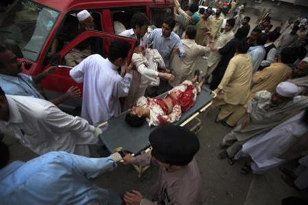 رجال يساعدون ضحايا هجوم انتحاري في بيشاور يوم أمس