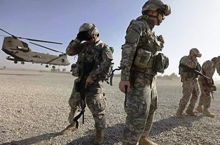 جنود أمريكيون يحاولون حماية أنفسهم من التراب الذي تثيره عملية إقلاع هليكوبتر في ساليرنو بأفغانستان يوم الثاني من ديسمبر
