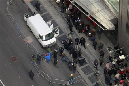 اعلاميون ومشاة يتأملون الشاحنة المقفلة المتوقفة في ميدان تايمز والتي عثر فيها على العبوة المريبة أمس الأربعاء