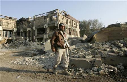 جندي عراقي بجانب الدمار الذي أحدثته الإنفجارات