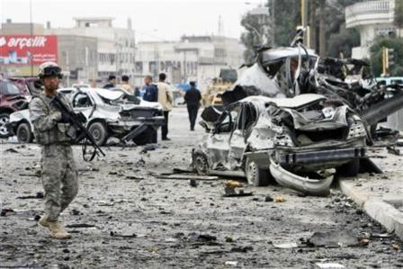 جندي أمريكي مناوب قرب حطام سيارات دمرت في هجوم بقنبلة في بغداد يوم أمس.