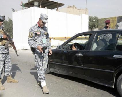 شرطي عراقي يفتش إحدى المركبات بواسطة السونار اليدوي
