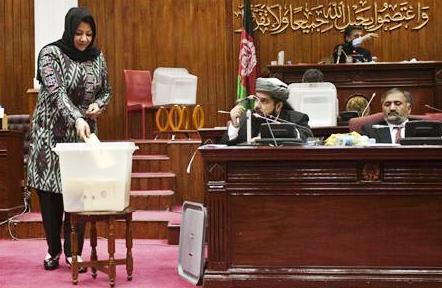عضوة في البرلمان الأفغاني تشارك في التصويت على الحكومة المقدمة من الرئيس حامد كرزاي في كابول يوم أمس .