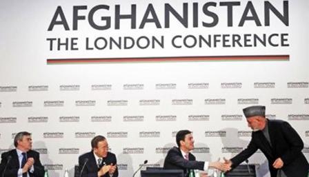 الرئيس الافغاني حامد كرزاي (إلى اليمين) يصافح وزير الخارجية البريطاني ديفيد ميليباند عقب خطابه في مؤتمر لندن بشأن أفغانستان في العاصمة البريطانية أمس الخميس
