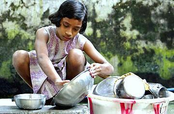 طفلة تقوم بغسل الصحون