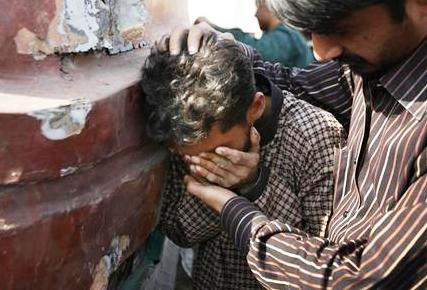رجل يبكي حزنا على قريب له قتل في انفجار في كراتشي.