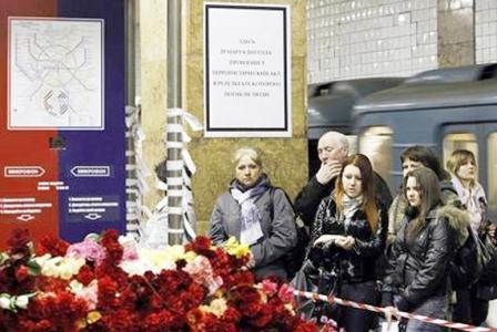 أشخاص بجوار نصب تذكاري مؤقت لضحايا تفجير في محطة لمترو الانفاق في موسكو يوم  أمس الثلاثاء.