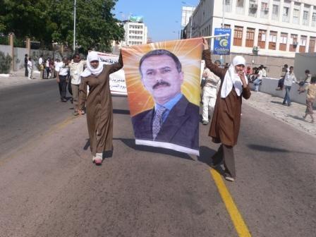 طالبتان تحملان صورة الرئيس القائد دلالة على الانتماء الوطني