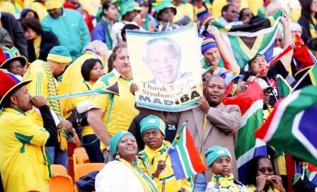 مشجعون في الحفل الافتتاحي يرفعون صورة مانديلا