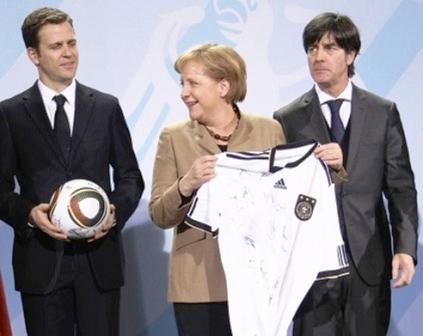 ميركل تتلقى قميص المنتخب الألماني تقديراً لدعمها