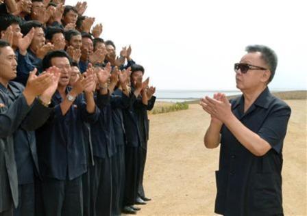 الزعيم الكوري الشمالي كيم جونج ايل (يمينا) يحيي بعض مواطني شعبه