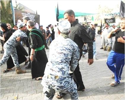 رجلا أمن عراقيان يفتشان زوارا قرب مرقد الإمام موسى الكاظم