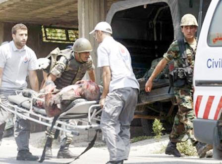 عمال إنقاذ يحملون جنديا لبنانيا أصيب في القصف الإسرائيلي على بلدة العديسة