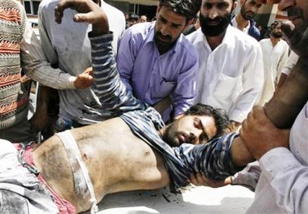 كشميريون يحاولون إسعاف شخص أصيب بعيار ناري  في أثناء الاحتجاج ضد الحكم الهندي لكشمير أمس  الأحد .
