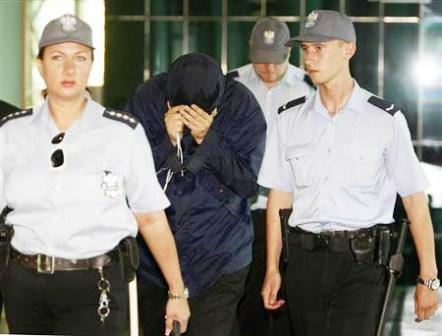 الجاسوس المشتبه به اوري برودسكي يخفي وجهه في محكمة في وارسو يوم 5 أغسطس 2010.