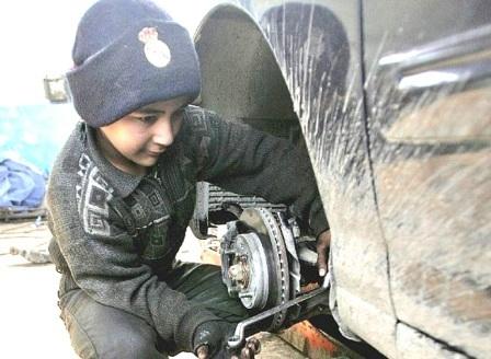 طفل يعمل في ورشة سيارات