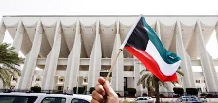 رجل يحمل علم الكويت أمام البرلمان في الكويت