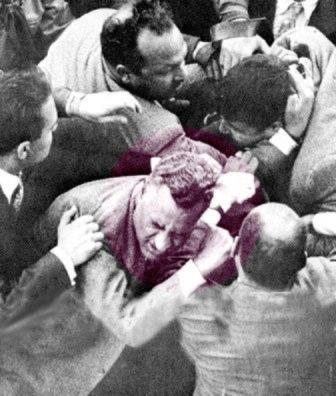 الرئيس جمال عبدالناصر بعد إطلاق النار عليه من قبل “المجاهد الإخواني” محمود عبداللطيف في الميدان المنشية بالاسكندرية يوم الأربعاء 27 أكتوبر 1954م، ويبدو تحت السهم الإخواني محمود عبداللطيف الذي حاول قتل عبدالناصر