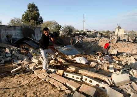 فلسطينيون يرفعون حطام منزل دمرته ضربة جوية إسرائيلية في خان يونس