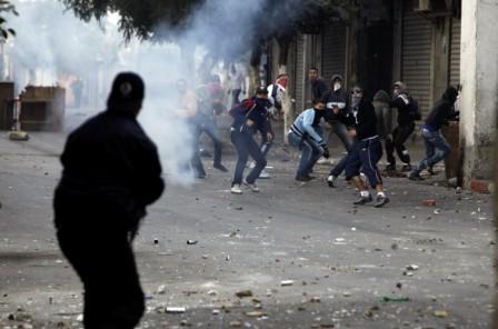 شرطي يلقي الغاز المسيل للدموع على محتجين خلال اشتباك في العاصمة الجزائرية يوم الجمعة الماضية.