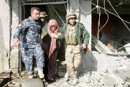 جنديان عراقيان يساعدان امرأة في موقع انفجار سيارة بالعراق