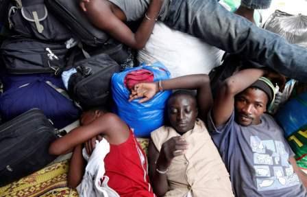 مهاجرون من مالي ينتظرون العودة الى بلادهم يرقدون بجوار سفارة مالي في ابيدجان أمس الخميس