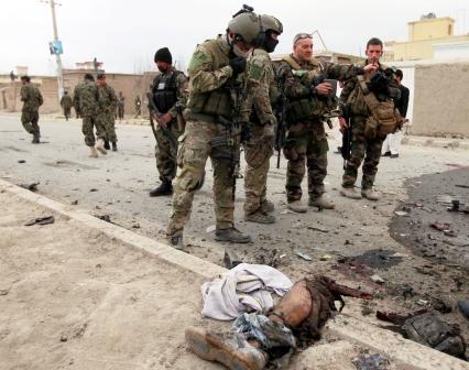 جنود أمريكيون  امام أشلاء  احد ضحايا العنف  في إقليم قندهار شمال أفغانستان .