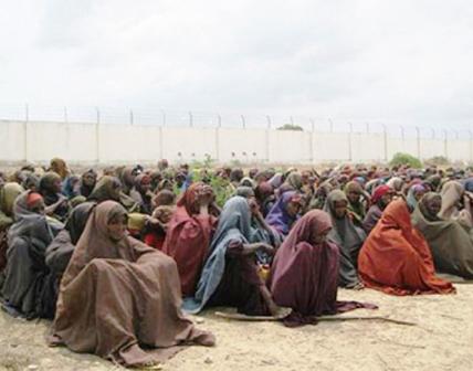 نساء ينتظرن توزيع مواد غذائية عليهن في مخيم لاستقبال النازحين بمقديشو
