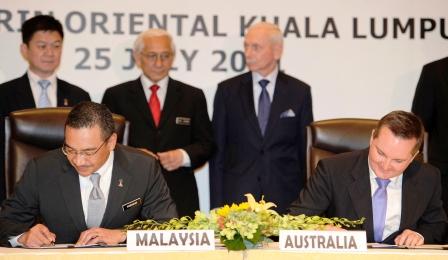 وزير الهجرة الاسترالي (إلى اليمين) ووزير الداخلية الماليزي بعد توقيع الاتفاق يوم  أمس الاثنين