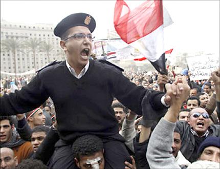 جموع من المصريين يحملون على اكتافهم شرطياً مصرياً تعبيراً عن تضامن الشرطة مع الشعب